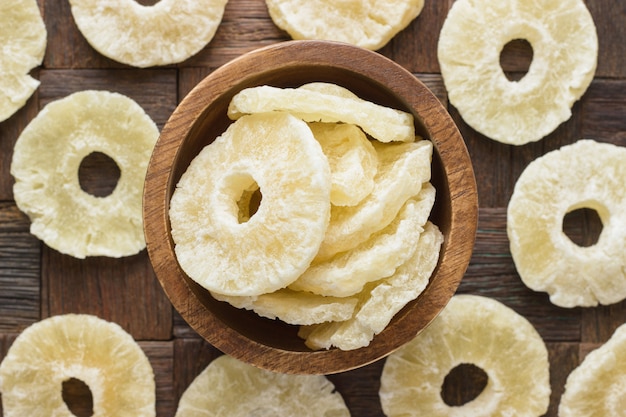 Photo dried pineapples in wooden bowl