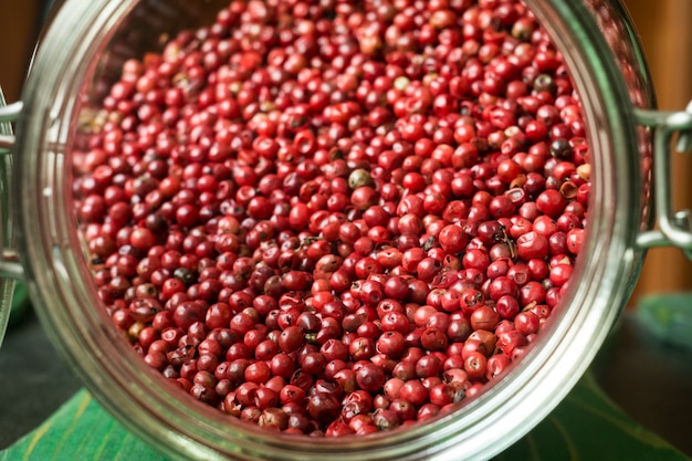 Dried pink pepper in a jar, closeup