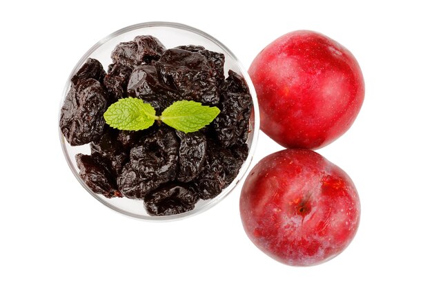 Dried plum in a glass bowl isolated on a white background top view