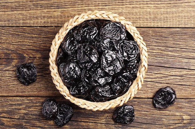 Dried plum in wicker bowl on the table