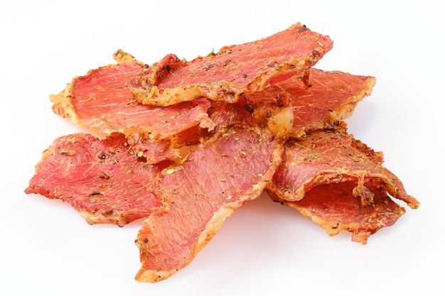 Dried pork jerky slices isolated on white background