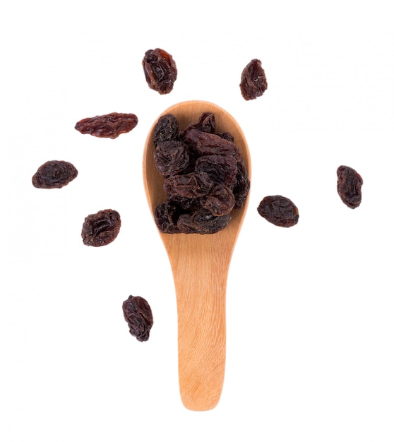 Dried raisins in spoon on white