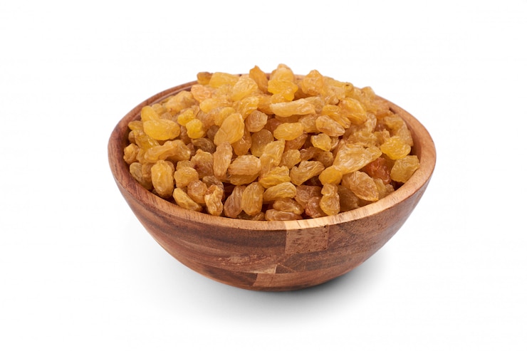 Photo dried raisins in wooden bowl