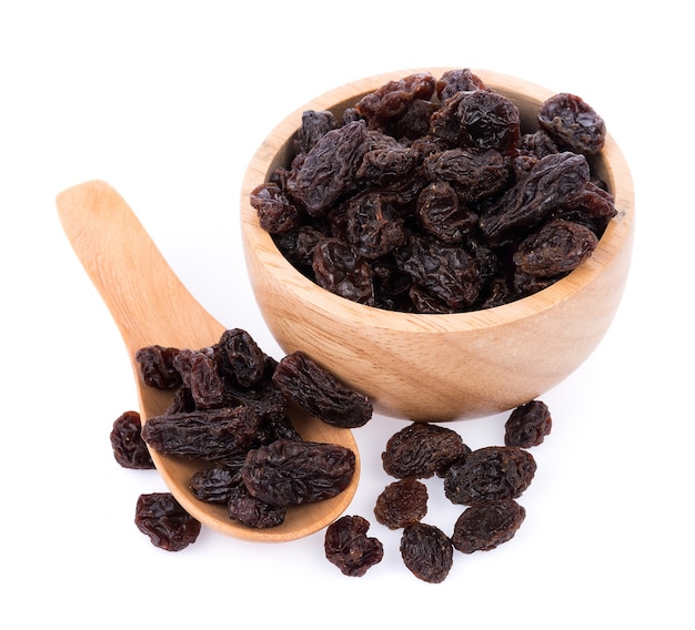 Dried raisins on Wooden Spoon on white