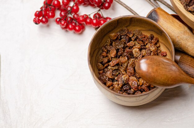 Dried raw raisins in wooden bowl. Natural raisins in a bowl. Bowl with dried raisins.