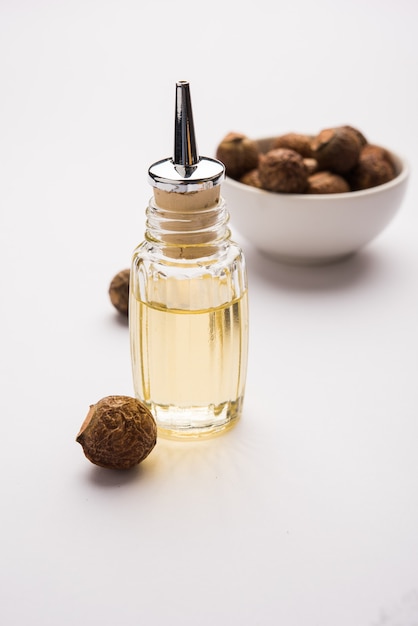 Dried raw Shikakai and Reetha OR Soapnut Powder in a bowl or essensial oil, selective focus