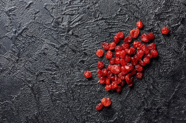 Photo dried red cherries on a black background with copy space.