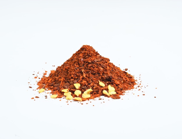 Dried red chili flakes and seeds isolated on white background