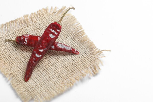 Dried red chillies on white surface