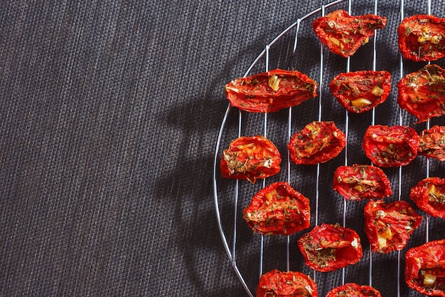 Dried red tomatoes arrangedÂ on dark