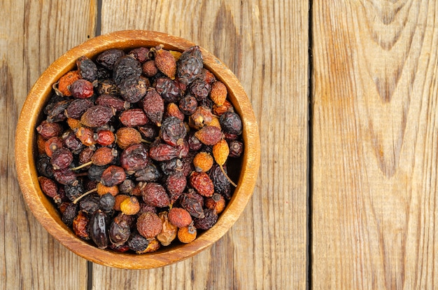 Dried rose hips in wooden bowl