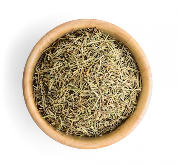 Photo dried rosemary leaves in wooden bowl over white