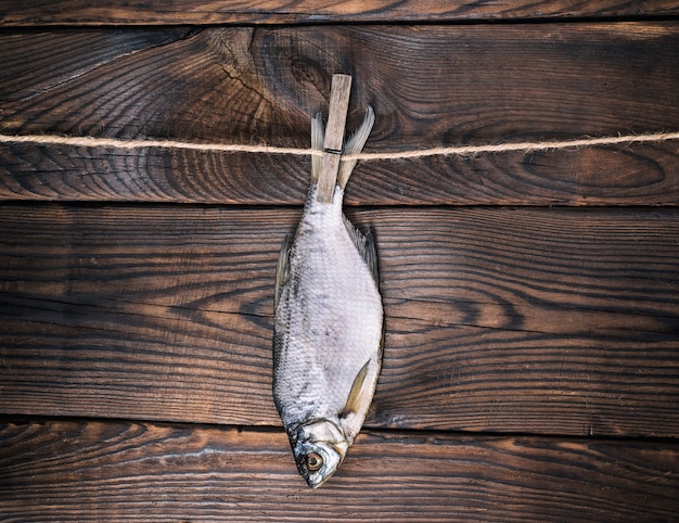 Вяленая соленая рыба баран висит на веревке