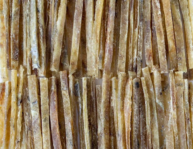 Dried salted tuna meat strips sliced or stacked in strips all over the background