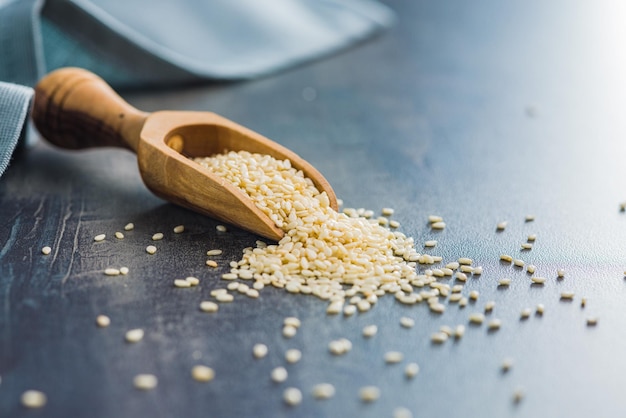 Dried sesame seeds in the wooden scoop