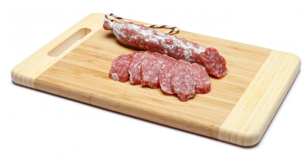 Dried sliced organic salami sausage on wooden cutting board