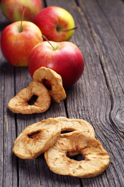 Photo dried sliced and red apples on vintage wooden background