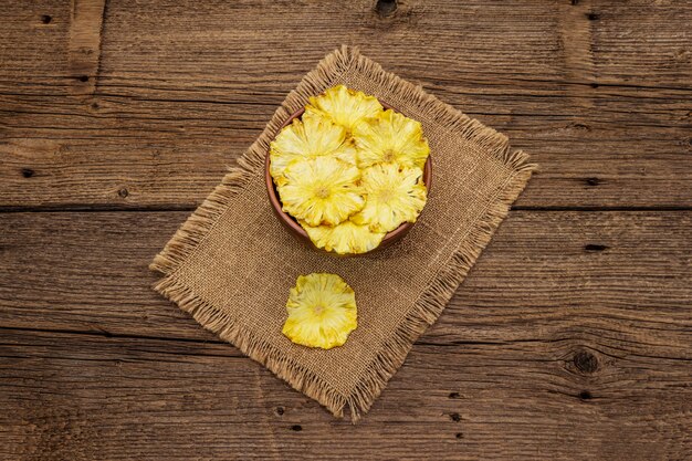 Фото Сушеные ломтики ананаса в миску. фруктовая закуска, концепция здорового питания