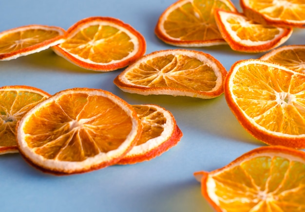 Dried slices oranges citrus fruit on light blue background. Homemade natural aroma decor. 