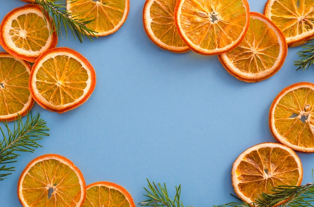 Dried slices oranges citrus fruit on light blue background. Homemade natural aroma decor. 