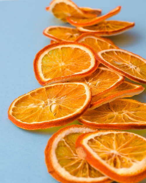 Dried slices oranges citrus fruit on light blue background. Homemade natural aroma decor. 