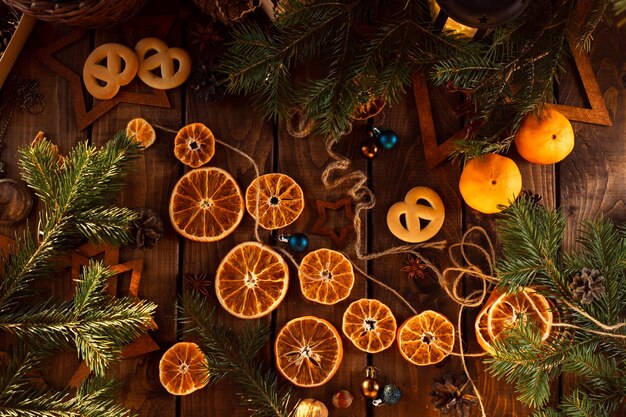 Dried slices of oranges cut into circles lie on a wooden table. New Year's Flatley.