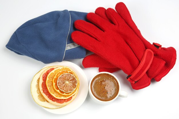 Dried slices of various citrus fruits and black coffee in a white Cup