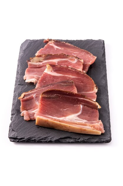 白い背景で隔離の乾燥および燻製肉スライス