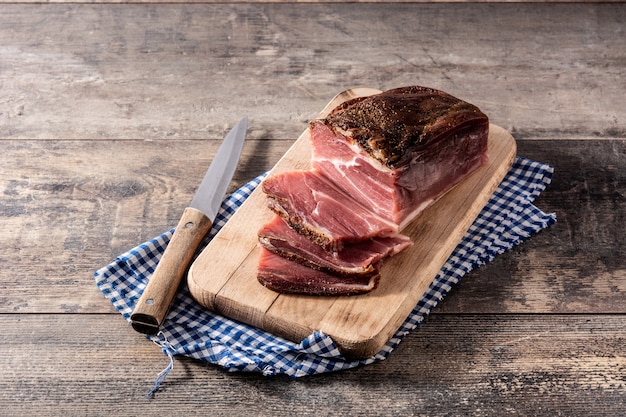 Dried and smoked meat on wooden table