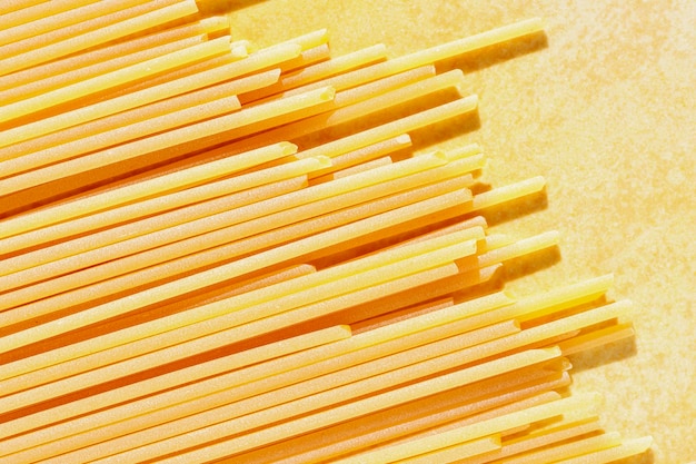 Foto spaghetti secchi su sfondo giallo