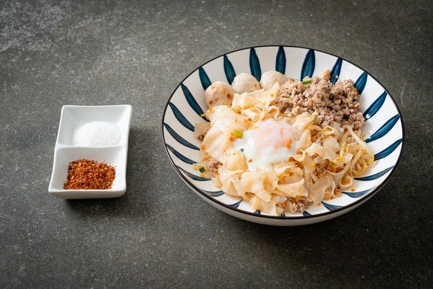 Noodles piccanti secchi con carne di maiale macinata, polpette e uova - stile asiatico