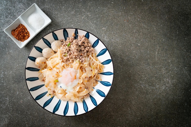 dried spicy noodles with minced pork, meatballs and egg - Asian food style