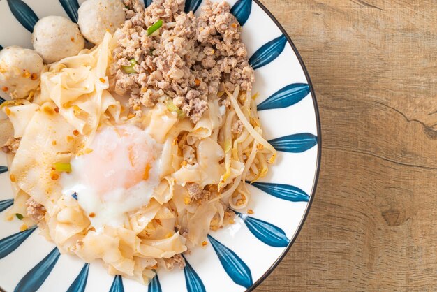 dried spicy noodles with minced pork, meatballs and egg - Asian food style