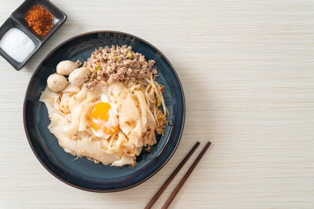 сушеная острая лапша с фаршем из свинины, фрикадельками и яйцом - стиль азиатской кухни