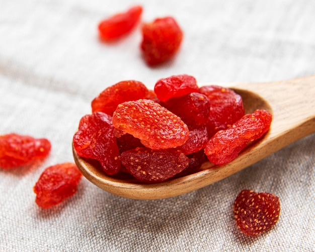 Dried Strawberries in spoon on a textile background