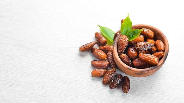 Dried sweet dates on white wooden background