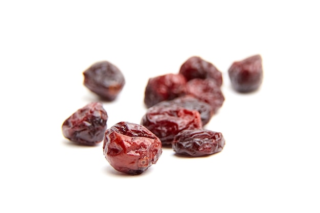 Dried and sweetened cranberries isolated on white background top view Heap scattered cranberries