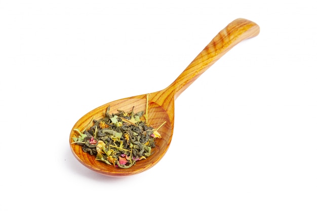 Dried tea on a wooden spoon, isolated on white
