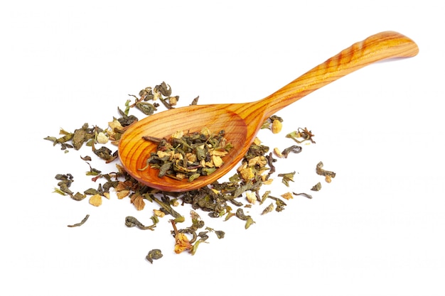 Dried tea on a wooden spoon, isolated on white