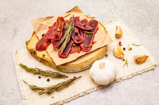 Dried tenderloin of beef meat with dry rosemary and pepper mix, chili and garlic on vintage linen cloth