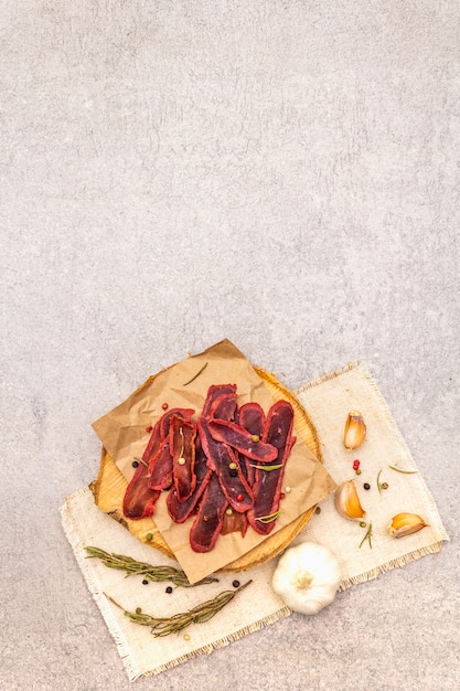 Dried tenderloin of beef meat with dry rosemary and pepper mix, chili and garlic on vintage linen cloth