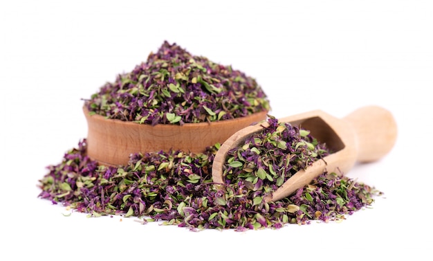 Dried thyme flowers in wooden bowl, isolated