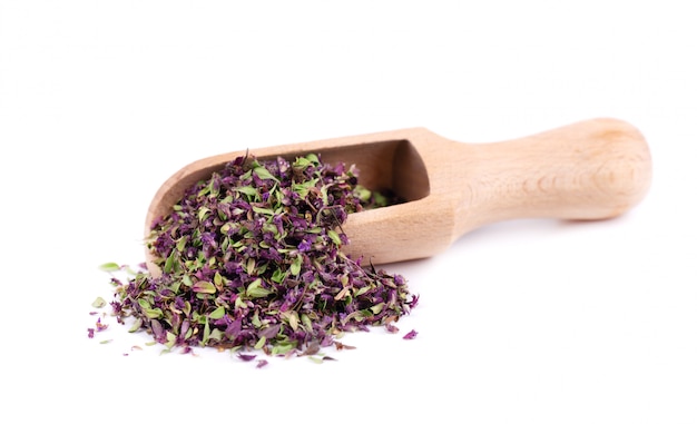 Dried thyme flowers in wooden spoon