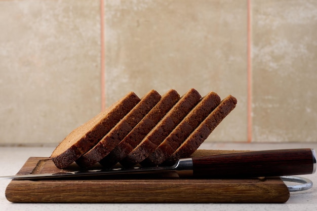 Driehoekig stuk roggebrood op een houten snijplank