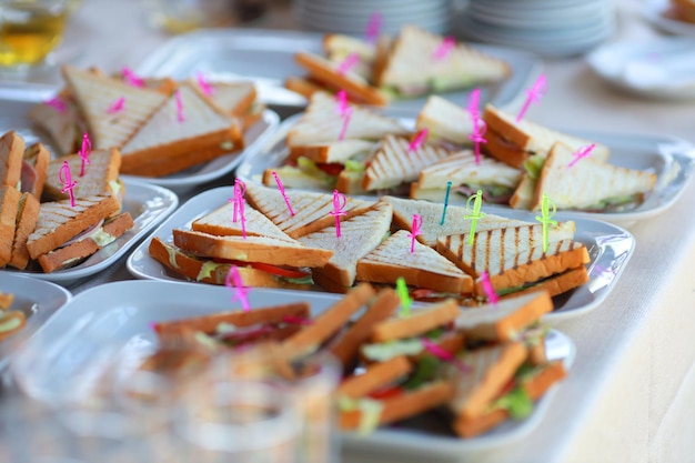 Driehoekige smakelijke sandwiches op een bord bij een evenement