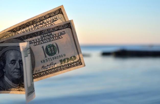 Driehonderd dollarbiljetten op de achtergrond van de dollar van het zeeoppervlak