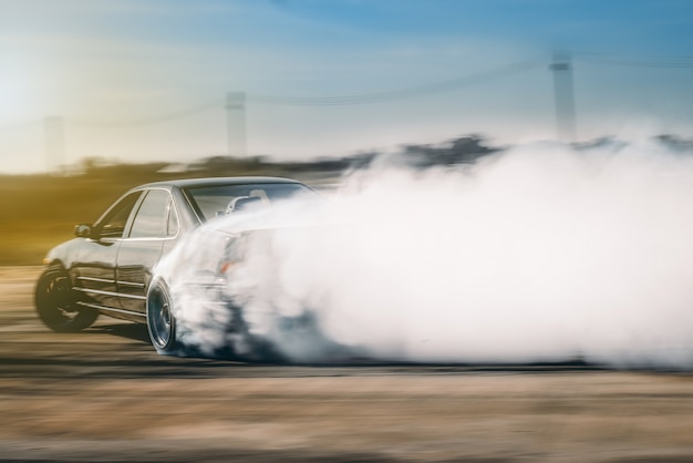drift driving is approaching the high speed curve and has a lot of smoke.