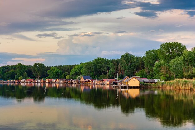 Drijvend dorp aan het Bokod-meer in de dramatische zonsonderganghemel van Hongarije