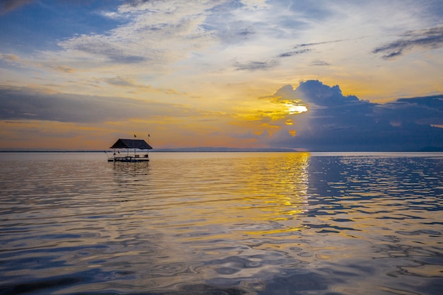 Drijvend huis op de dijk met Zonsondergangachtergrond