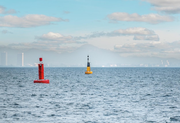 Drijvende rode navigatieboei op blauwe zee Mariene signaalboei Navigatieboei die een vaargeul markeert